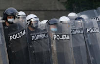 Serbian riot police shields themselves as they clash with protesters in Belgrade, Serbia, Wednesday, July 8, 2020. Serbia's president Aleksandar Vucic backtracked Wednesday on his plans to reinstate a coronavirus lockdown in Belgrade after thousands protested the move and violently clashed with the police in the capital. (AP Photo/Darko Vojinovic)