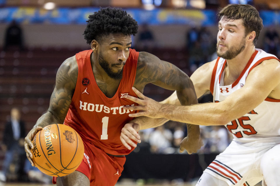 Houston's Jamal Shead (1) dribbles against the defense of Utah's Rollie Worster (25) in the first half of an NCAA college basketball game during the Charleston Classic in Charleston, S.C., Friday, Nov. 17, 2023. (AP Photo/Mic Smith).