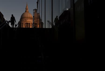 Workers cross the Millenium Bridge during the morning rush hour in the City of London in London, in this December 16, 2014 file photo. REUTERS/Toby Melville/Files