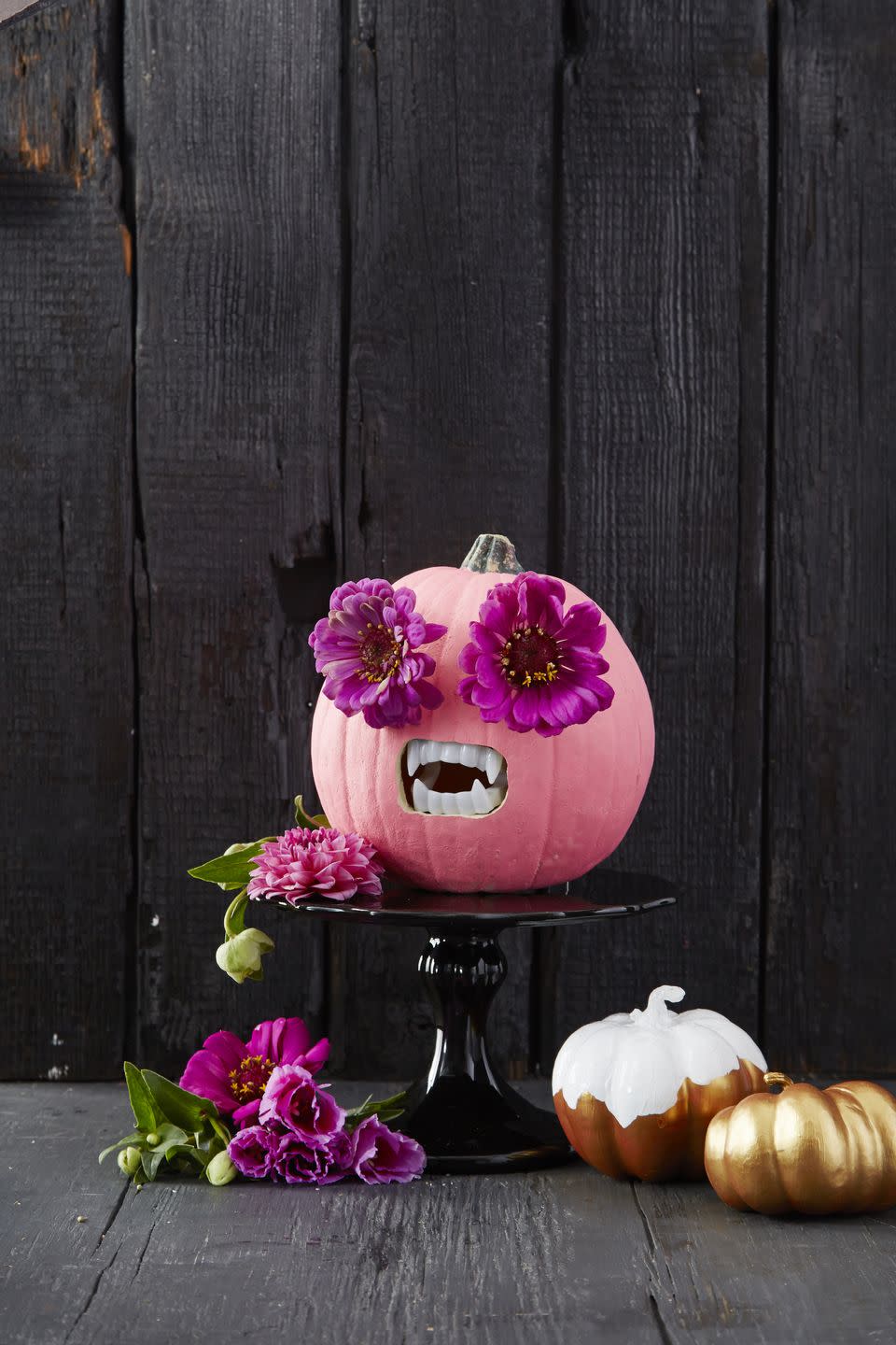 <p>This idea is perfect for the family that wants to make a big statement without spending a ton of time creating their design. All you have to do is paint your pumpkin bright pink (or any color you'd like). Then, just make holes for the eyes and mouth, and pop in some giant faux flowers and scary fake teeth! </p><p><a class="link " href="https://www.amazon.com/Fun-Express-Plastic-Halloween-Vampire/dp/B005MRN04E/?tag=syn-yahoo-20&ascsubtag=%5Bartid%7C10055.g.238%5Bsrc%7Cyahoo-us" rel="nofollow noopener" target="_blank" data-ylk="slk:SHOP FAKE TEETH;elm:context_link;itc:0;sec:content-canvas">SHOP FAKE TEETH</a></p>