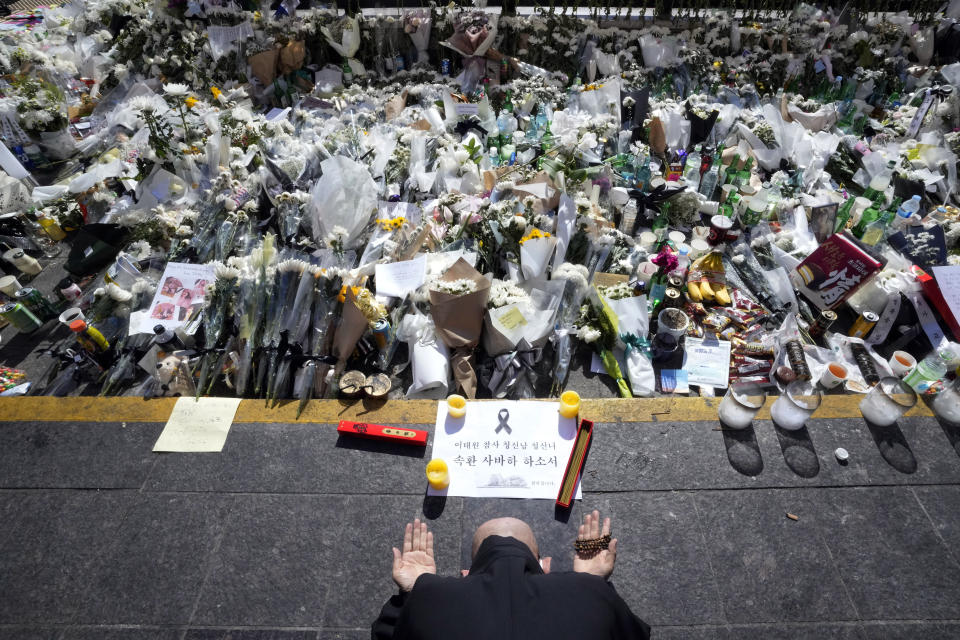 A Buddhist monk prays for victims of a deadly accident during Saturday night's Halloween festivities, at a makeshift flower-laying area set up near the scene of the accident in Seoul, South Korea, Wednesday, Nov. 2, 2022. (AP Photo/Ahn Young-joon)