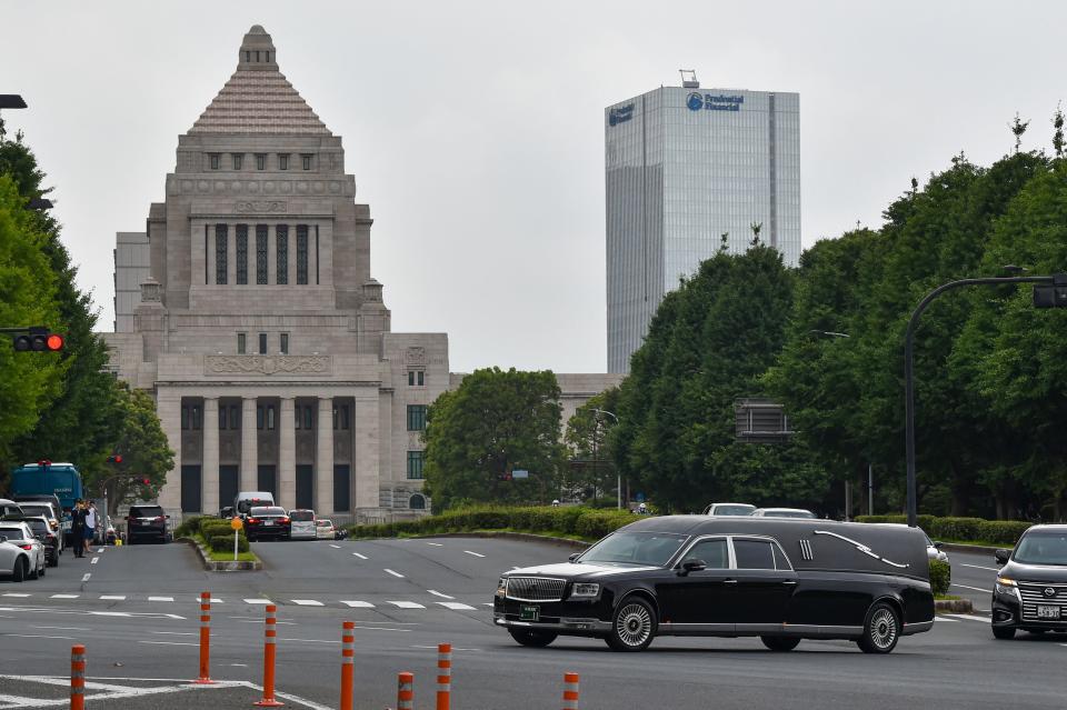 A hearse transporting the body of late former Japanese prime minister Shinzo Abe drives past the Diet Building (rear) in Tokyo on July 12, 2022. (Photo by Kazuhiro NOGI / AFP) (Photo by KAZUHIRO NOGI/AFP via Getty Images)