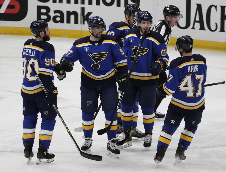 St. Louis Blues' David Perron (57) celebrates with Ryan O'Reilly (90), Torey Krug (47), Mike Hoffman (68) and Brayden Schenn (10) after scoring his second goal of the night, during the third period of an NHL hockey game against the Minnesota Wild, Thursday, May 13, 2021 in St. Louis. The Blues erased a 3-0 deficit to win 7-3. (AP Photo/Tom Gannam)
