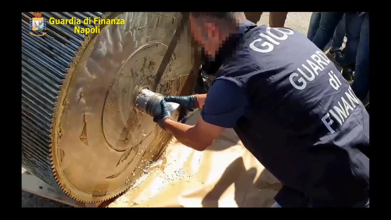 An undated handout image shows an Italian finance police officer opening a machinery that contains ISIS produced amphetamine pills in Salerno
