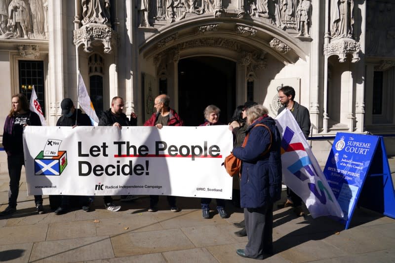 支持蘇格蘭獨立的民眾在英國最高法院外舉起布條，要求「讓人民決定」。（美聯社）