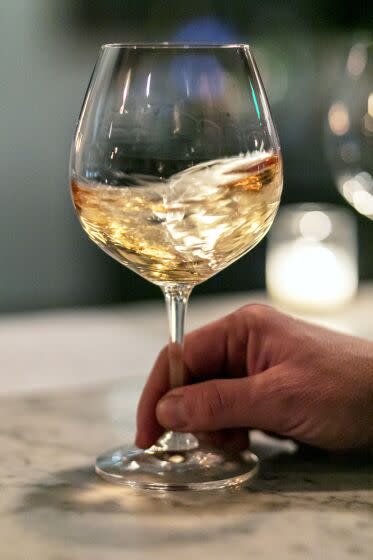 LOS ANGELES, CALIFORNIA - Jan. 30, 2020: A customer swirls his wine to open up its bouquet while drinking wine at Augustine Wine Bar on Thursday evening, Jan. 30, 2020. The moody, hip spot on Ventura Boulevard in Sherman Oaks, which specializes in vintage wines, was opened by Dustin Lancaster, Matthew Kaner and Dave Gibbs in 2015. (Silvia Razgova / For The Times) Assignment ID: 485394