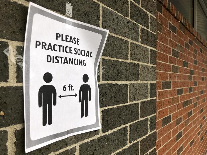 A sign encouraging social distancing is posted on Aldi&#39;s grocery store in Belvidere on March 26, 2020, during the onset of the coronavirus pandemic.
