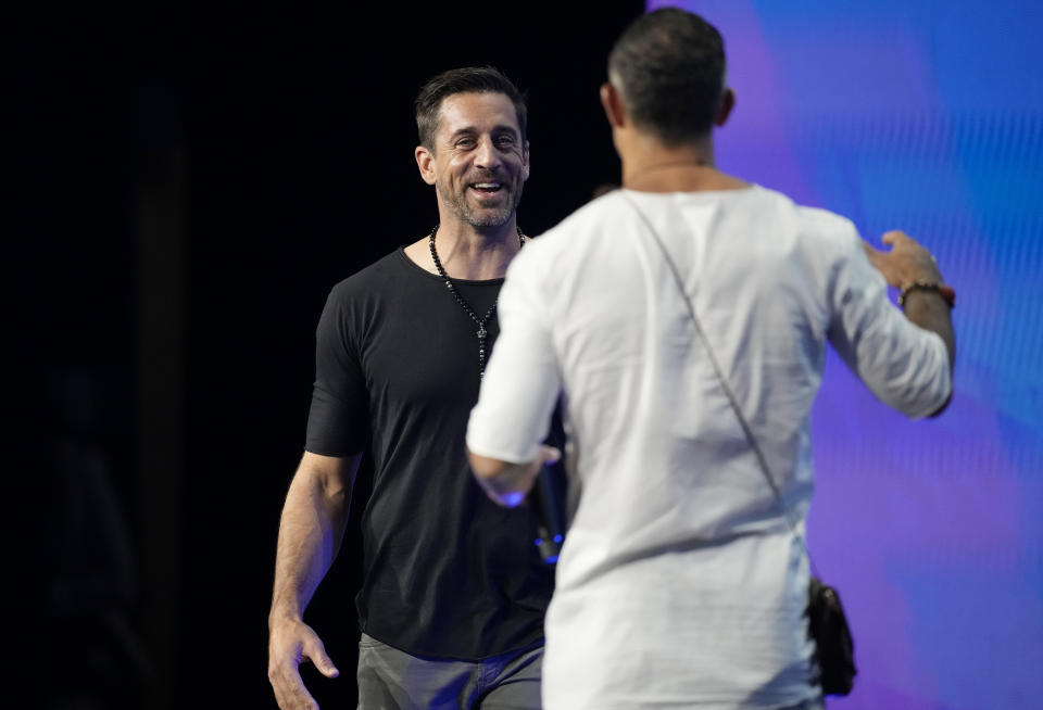 New York Jets quarterback Aaron Rodgers, back, is greeted by entrepreneur Aubrey Marcus for a program at the Psychedelic Science conference in the Colorado Convention Center Wednesday, June 21, 2023, in Denver. (AP Photo/David Zalubowski)