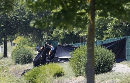 French Gendarmes stand guard next to a black plastic sheet outside a gas company site at the industrial area of Saint-Quentin-Fallavier, near Lyon, France, June 26, 2015. REUTERS/Emmanuel Foudrot