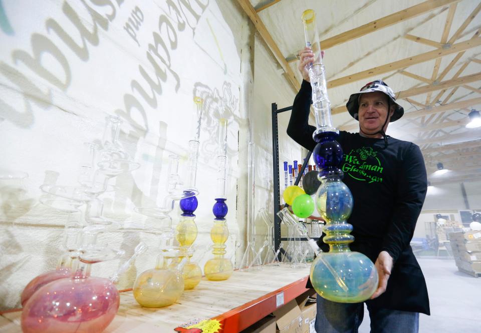 Joesph Spina, co-owner of Weedman and Glassman in Bolivar, shows off one of the many glass bongs his company sells on Friday Feb. 3, 2023. 