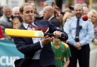 Britain's Prince William reacts as he tries to hit a ball using a cricket bat as he and his wife Catherine, the Duchess of Cambridge, attend a promotional event for the upcoming Cricket World Cup in Christchurch April 14, 2014. The Prince and his wife Kate are undertaking a 19-day official visit to New Zealand and Australia with their son George. REUTERS/Phil Noble (NEW ZEALAND - Tags: ROYALS ENTERTAINMENT POLITICS TPX IMAGES OF THE DAY)