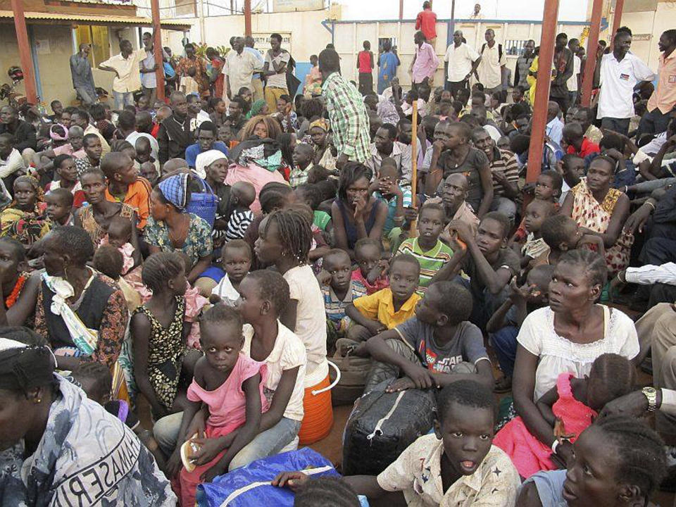In this image released by the United Nations Mission Juba, civilians sit after arriving at the compound of the United Nations Mission in the Republic of South Sudan (UNMISS), adjacent to Juba International Airport, to take refuge Wednesday, Dec. 18 , 2013, in Juba, South Sudan. (AP Photo/UNMISS, Rolla Hinedi)