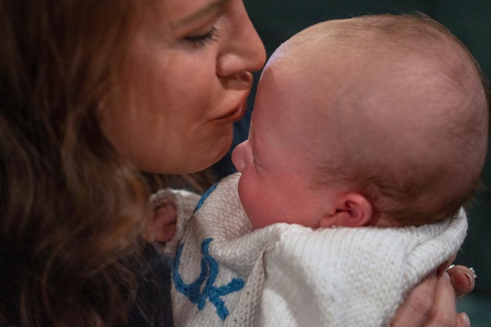 Emma Kelly kisses her son, Duke, Thursday, Nov. 16, 2023, at her home. "It's a huge loss and a trauma," she said of going into premature labor, "and it's alright to grieve what you thought it should be."