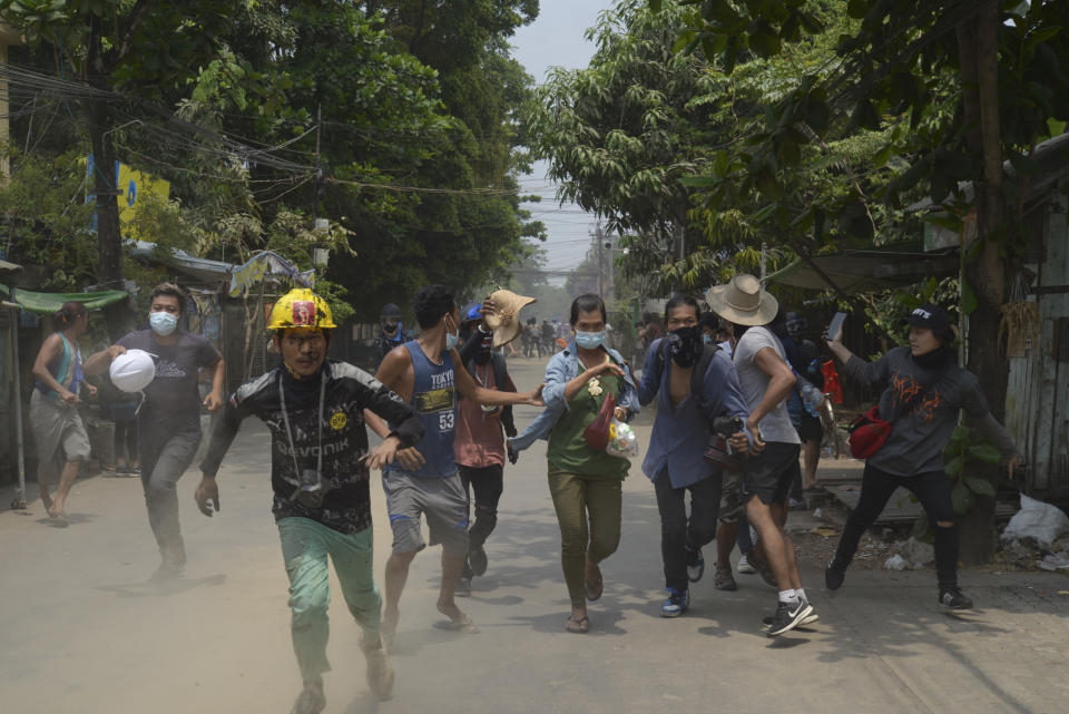Anti-coup protesters run to avoid the military during a demonstration in Yangon, Myanmar on Tuesday March 30, 2021. (AP Photo)