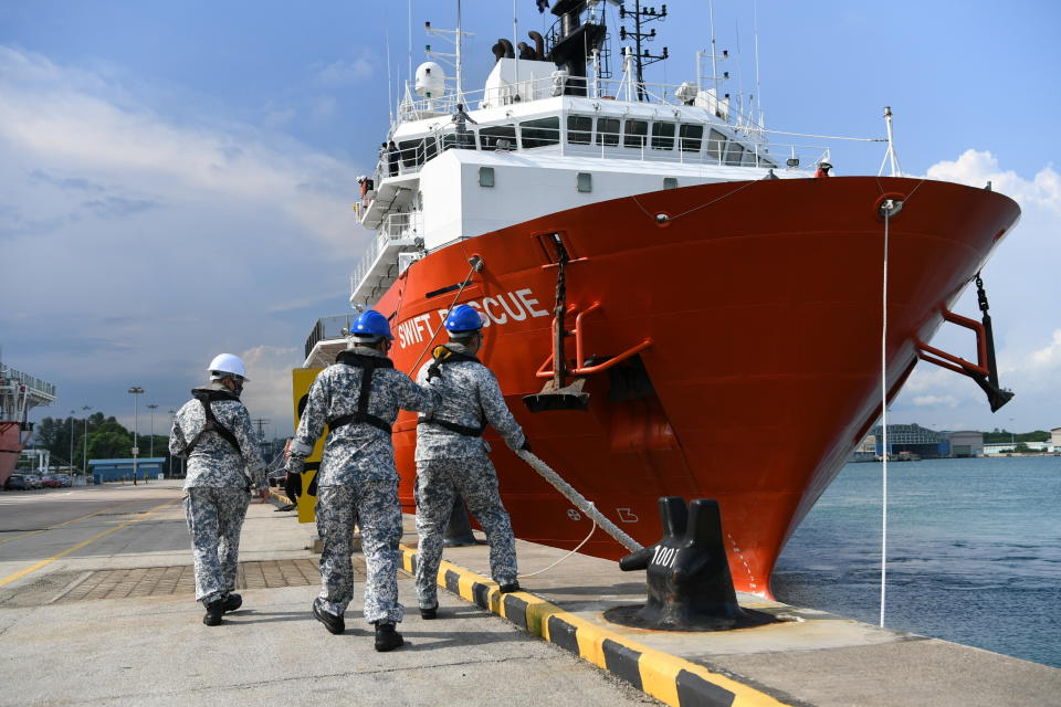 Officers work near Singapore Navy's MV Swift Rescue ahead of rescue efforts regarding Indonesia's missing submarine KRI Nanggala-402, in Singapore.