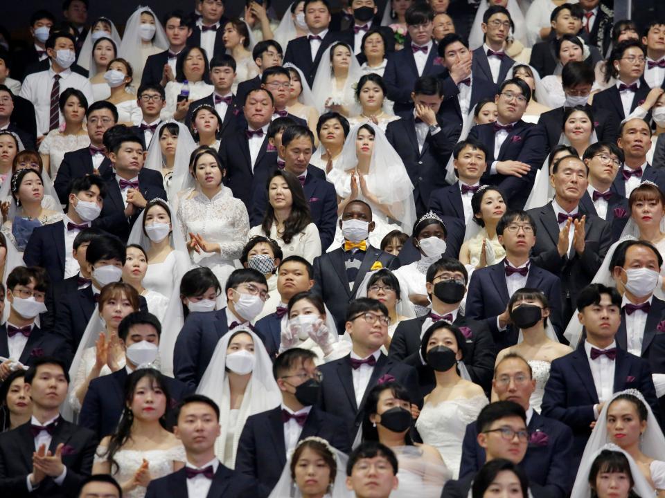Couples wearing masks for protection from the new coronavirus, attend a mass wedding ceremony of the Unification Church at Cheongshim Peace World Centre in Gapyeong, South Korea, February 7, 2020.   REUTERS/Heo Ran