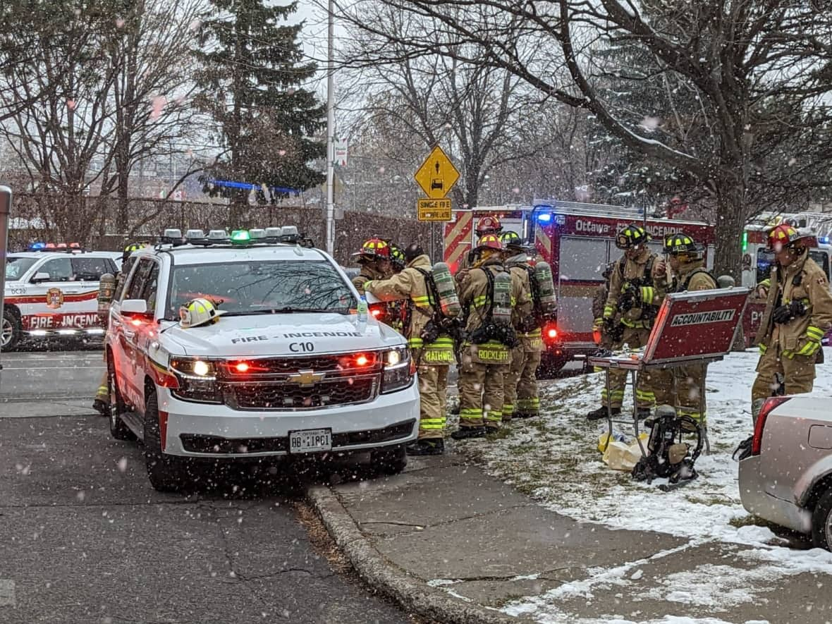 Firefighters work in the falling snow following a fire at Gladstone Terrace, the first of two set at the building in nine days. (Scott Stilborn/Ottawa Fire Services - image credit)