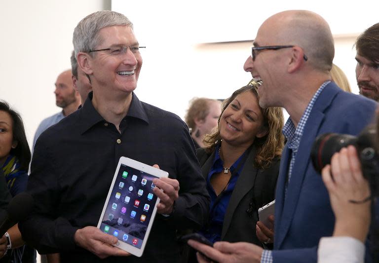 Apple CEO Tim Cook holds the new iPad Air 2 as he speaks with reporters during an Apple special event on October 16, 2014 in Cupertino, California