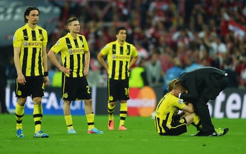 Neven Subotic, Lukasz Piszczek and Nuri Sahin of Borussia Dortmund look on as Marco Reus is consoled by Head Coach Jurgen Klopp of Borussia Dortmund in defeat after the UEFA Champions League final match between Borussia Dortmund and FC Bayern Muenchen at Wembley Stadium - Credit: Getty images