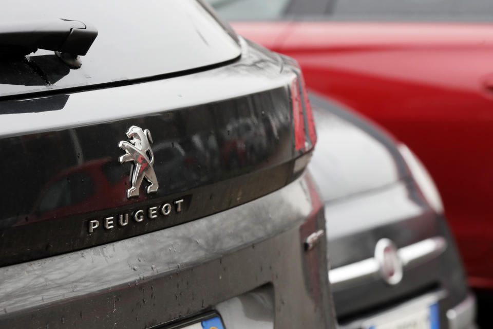 A Peugeot 3008 car is parked flanked by a 500 Fiat car in Milan, Italy, Wednesday, Dec. 18, 2019. Fiat Chrysler and PSA Peugeot have signed a deal for a 50-50 merger, creating the world's fourth-largest automaker with annual sales of 8.7 million cars. (AP Photo/Luca Bruno)