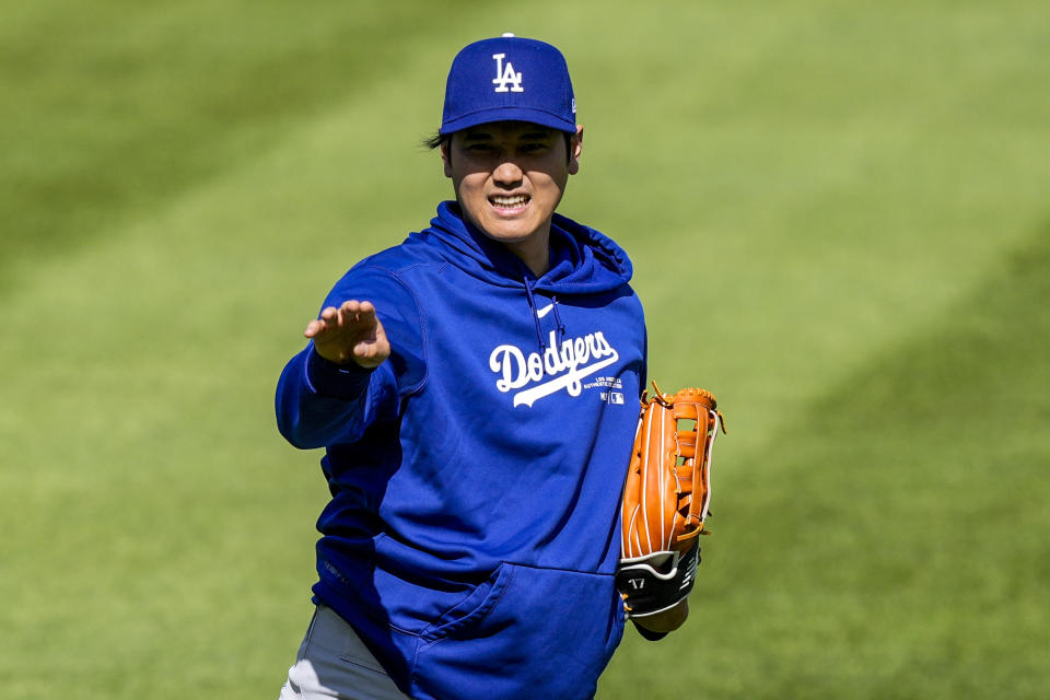 Los Angeles Dodgers' Shohei Ohtani reacts as he throws before a baseball game against the Washington Nationals at Nationals Park, Tuesday, April 23, 2024, in Washington. (AP Photo/Alex Brandon)