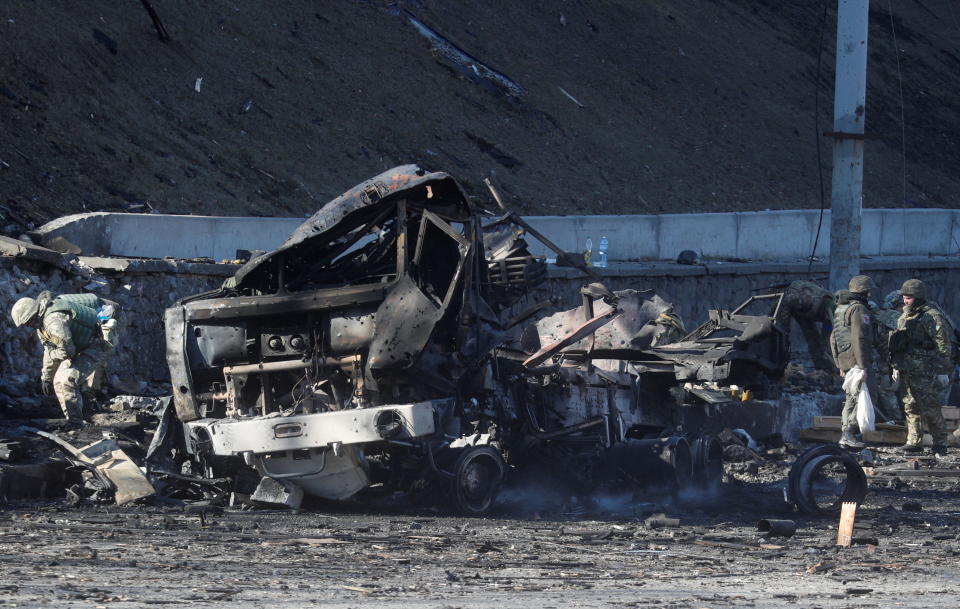 Ukrainian servicemen stand by a damaged vehicle, at the site of fighting with Russian troops, after Russia launched a massive military operation against Ukraine, in Kyiv, Ukraine February 26, 2022. REUTERS/Valentyn Ogirenko