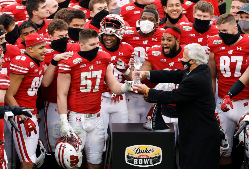 Wisconsin linebacker Jack Sanborn is handed the MVP award following the Badgers' 42-28 win over Wake Forest in the Duke's Mayo Bowl that followed the 2020 season.