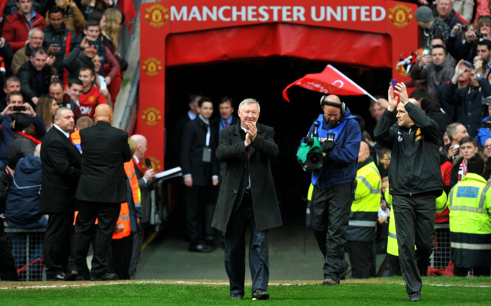 Sir Alex Ferguson walks onto the pitch to lift the Barclays Premier League trophy after the Barclays Premier League match at Old Trafford, Manchester.