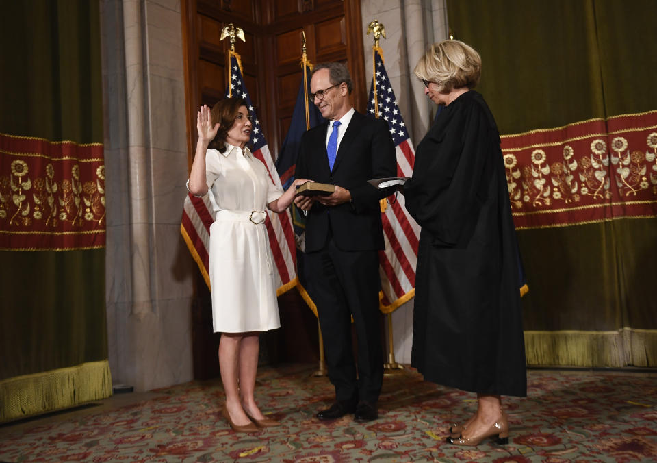 New York Chief Judge Janet DiFiore swears in Kathy Hochul as the first woman to be New York's governor while her husband Bill Hochul holds a bible during a ceremonial swearing-in ceremony at the state Capitol, Tuesday, Aug. 24, 2021, in Albany, N.Y. (AP Photo/Hans Pennink, Pool)