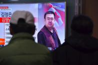 People in a Seoul railway station watch a TV news report on the death of Kim Jong-Nam