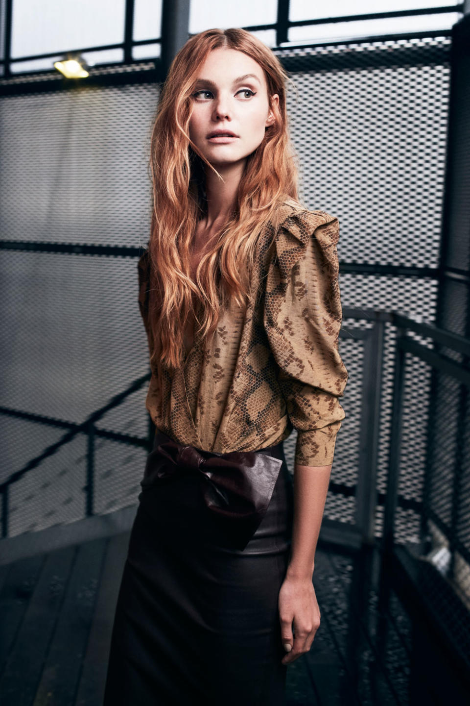 A model wears a snakeskin-print silk blouse and leather skirt from the Zeynep Arçay fall-winter 2017 collection.