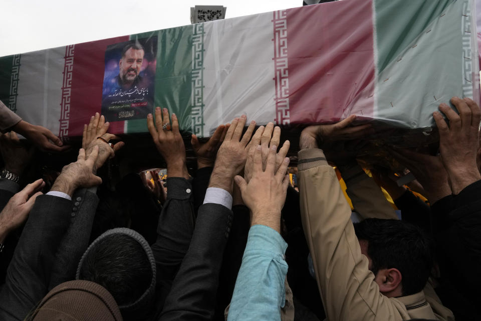 Iranian mourners carry the flag-draped coffin of Seyed Razi Mousavi, a high ranking Iranian general of the paramilitary Revolutionary Guard, who was killed in an alleged Israeli airstrike in Syria on Monday, during his funeral ceremony in Tehran, Iran, Thursday, Dec. 28, 2023. (AP Photo/Vahid Salemi)