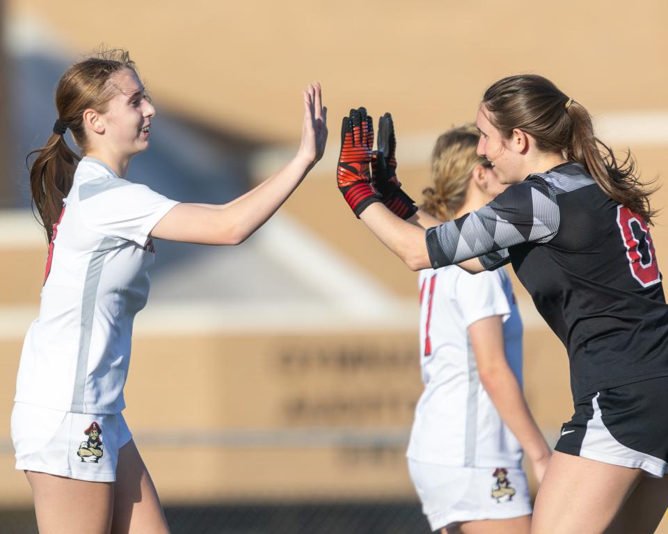Pinckney's Kinley Mays (left), who scored a hat trick, celebrates her first high school goal with goalie Peyton Delongchamp Monday, April 8, 2024.