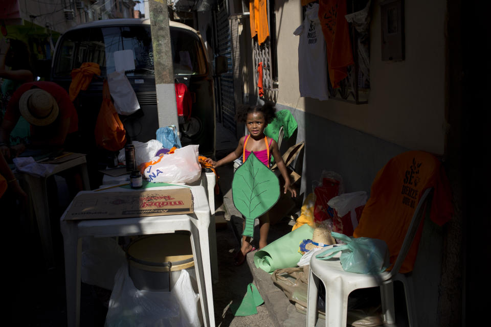 A girl dressed as a leaf prepares to participate in the "Se Benze que da" block party, created by slain councilwoman Marielle Franco, in the Mare slum of Rio de Janeiro, Brazil, Saturday, Feb. 23, 2019. Merrymakers take to the streets in hundreds of open-air "bloco" parties ahead of Rio's over-the-top Carnival, the highlight of the year for many. (AP Photo/Silvia Izquierdo)