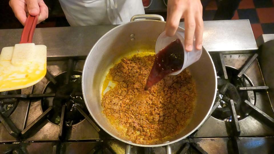 Chef Mario Carbone adding red wine to his Sunday sauce.  / Credit: CBS News