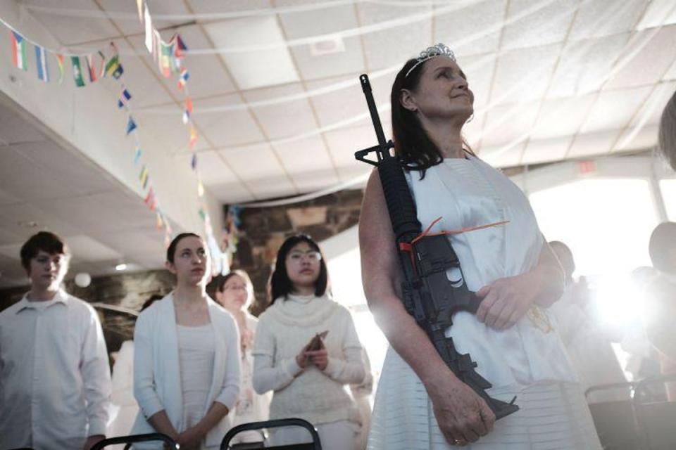 A woman holds an AR-15 rifle during a ceremony at the World Peace and Unification Sanctuary in Newfoundland, Pennsylvania (Getty Images North America)