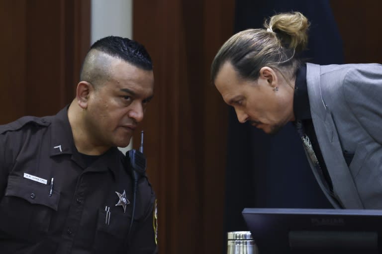 Actor Johnny Depp talks to a deputy sheriff at his defamation trial against his ex-wife Amber Heard (AFP/EVELYN HOCKSTEIN)
