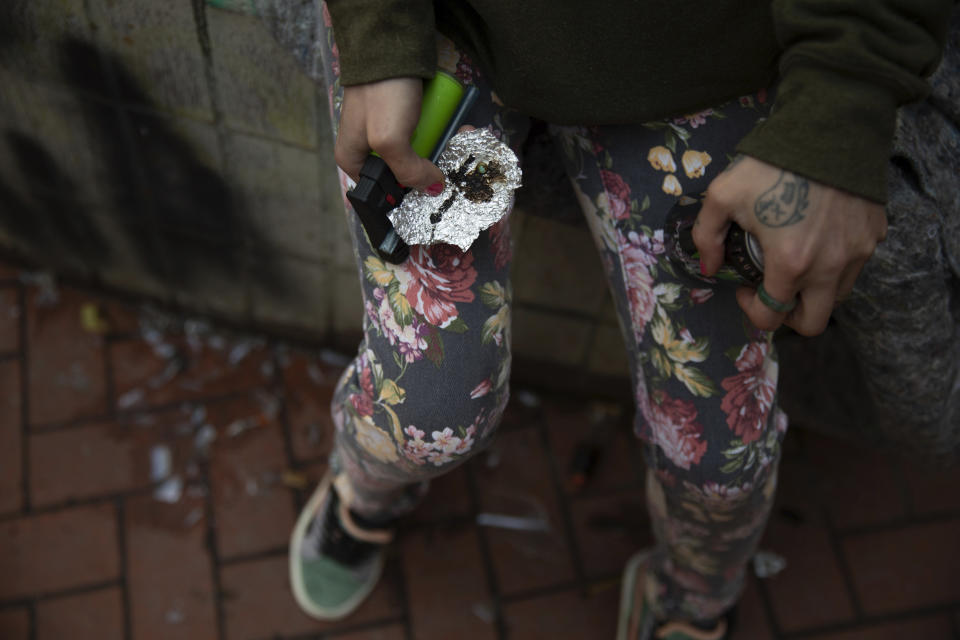 A person holds drug paraphernalia near the Washington Center building on SW Washington St. in downtown Portland, Ore., where heavy drug use has become common. Three years ago, nearly two-thirds of Oregon voters approved a ballot measure decriminalizing illicit drugs, backing the idea that addiction treatment is more effective than jail. But now, public drug use in cities such as Portland and a surge in fentanyl overdose deaths have created a backlash against the first-in-the-nation law. (Dave Killen/The Oregonian via AP)