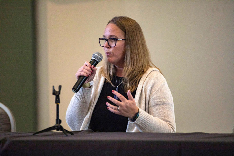 Carrie as an adult speaking into a microphone