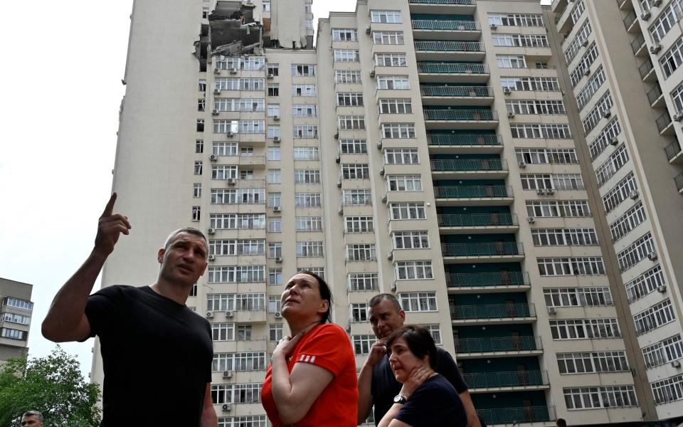 TOPSHOT - Kyiv's Mayor Vitali Klitschko talks with local residents next to a 24-storey building partially destroyed following a Russian missiles strike in Kyiv early on June 24, 2023. Ukraine was on high alert after a fresh barrage of Russian missiles on June 24, 2023, with casualties and damage reported in Kyiv and the central city of Dnipro. (Photo by Sergei CHUZAVKOV / AFP) (Photo by SERGEI CHUZAVKOV/AFP via Getty Images)