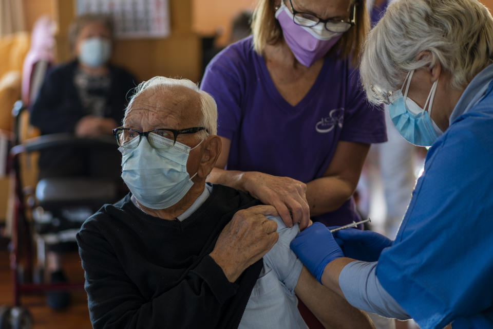 A nurse administers the Pfizer-BioNTech COVID-19 vaccine to a resident at Icaria nursing home in Barcelona, Spain, Tuesday, Jan. 12, 2021. Spain's rate of infection has shot up to 435 cases per 100,000 residents in the past two weeks, prompting new restrictions as authorities try to bring vaccination up to speed. (AP Photo/Emilio Morenatti)