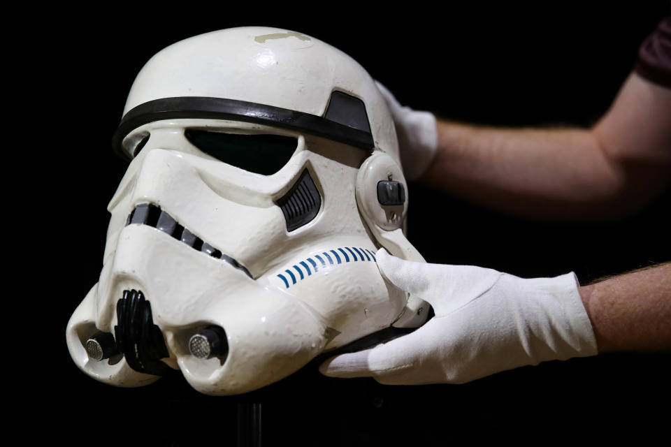 Embargoed to 0001 Tuesday August 20 A prop store employee adjusts a screen matched Tantive IV Stormtrooper helmet from 1977 film Star Wars: A New Hope (estimate ??120-180,000), during a preview of the forthcoming film and television memorabilia auction at the Prop Store head office near Rickmansworth.