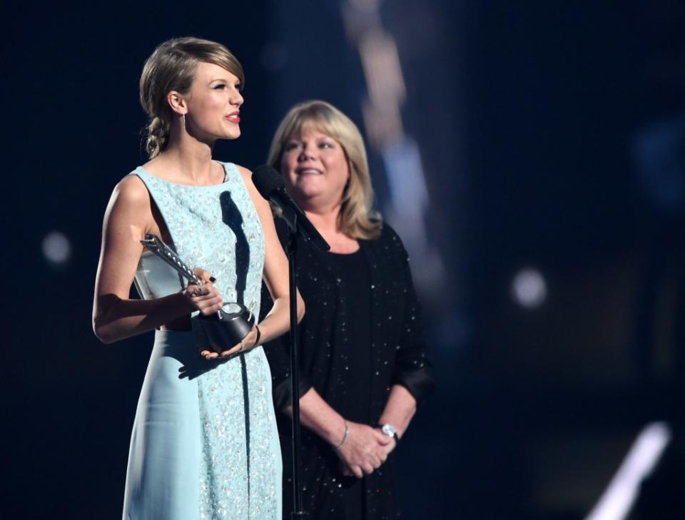Taylor Swift accepts the Milestone Award from Andrea Swift at the 50th Academy of Country Music Awards. Cooper Neill