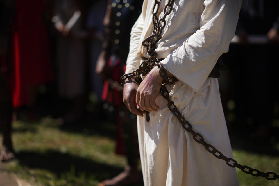 An actor, playing the role of Jesus Christ, stands in chains during a Way of the Cross reenactment, as part of Holy Week celebrations, in Atyra, Paraguay, Friday, March 29, 2024. Holy Week commemorates the last week of Jesus' earthly life which culminates with his crucifixion on Good Friday and his resurrection on Easter Sunday. (AP Photo/Jorge Saenz)