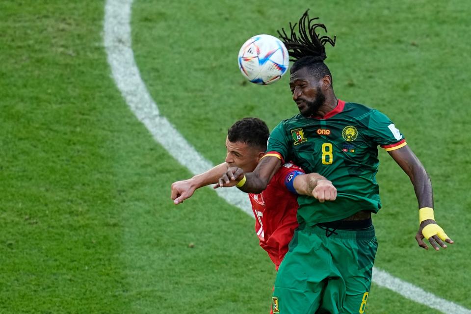 Switzerland's Granit Xhaka jumps for a header with Cameroon's Andre-Frank Zambo Anguissa, right, during their World Cup group G soccer match.