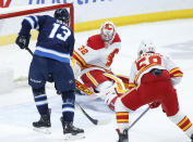 Winnipeg Jets' Gabriel Vilardi (13) scores on Calgary Flames goaltender Dustin Wolf (32) as Oliver Kylington (58) defends during the first period of an NHL hockey game Thursday, April 4, 2024, in Winnipeg, Manitoba. (John Woods/The Canadian Press via AP)