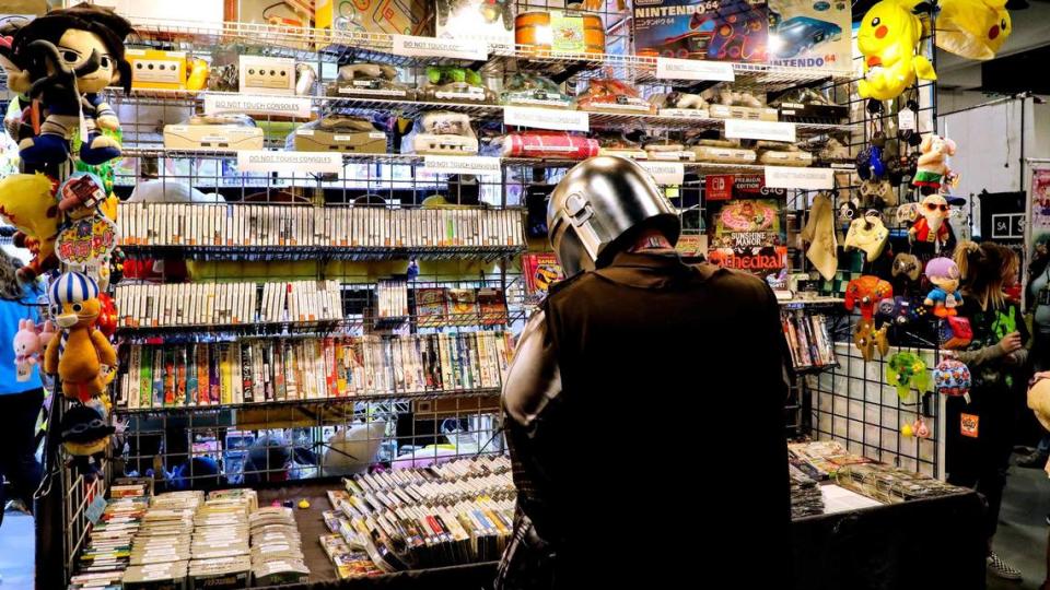 A patron looks over items for sale from a vendor on the exhibit floor during the 2022 Lexington Comic and Toy Convention at the Central Bank Center. Vendors were selling rare toys and collectibles, comics, art work and pop culture goods from their booths.