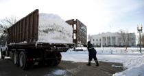 A worker opens the dump truck gate to dump snow into a cleared area of Pennsylvania Avenue in front of the White House in Washington January 25, 2016. REUTERS/Kevin Lamarque