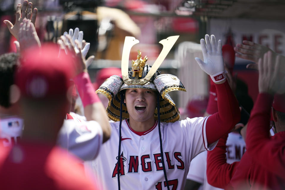 Los Angeles Angels' Shohei Ohtani celebrates his two-run home run in the dugout during the third inning of a baseball game against the Toronto Blue Jays Sunday, April 9, 2023, in Anaheim, Calif. (AP Photo/Marcio Jose Sanchez)