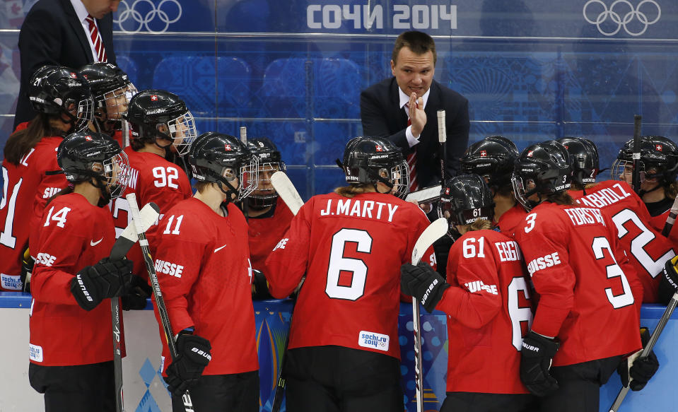 Switzerland head coach Rene Kammerer talks to players during timeout during the first period of the 2014 Winter Olympics women's semifinal ice hockey game against Canada at Shayba Arena, Monday, Feb. 17, 2014, in Sochi, Russia. (AP Photo/Julio Cortez)